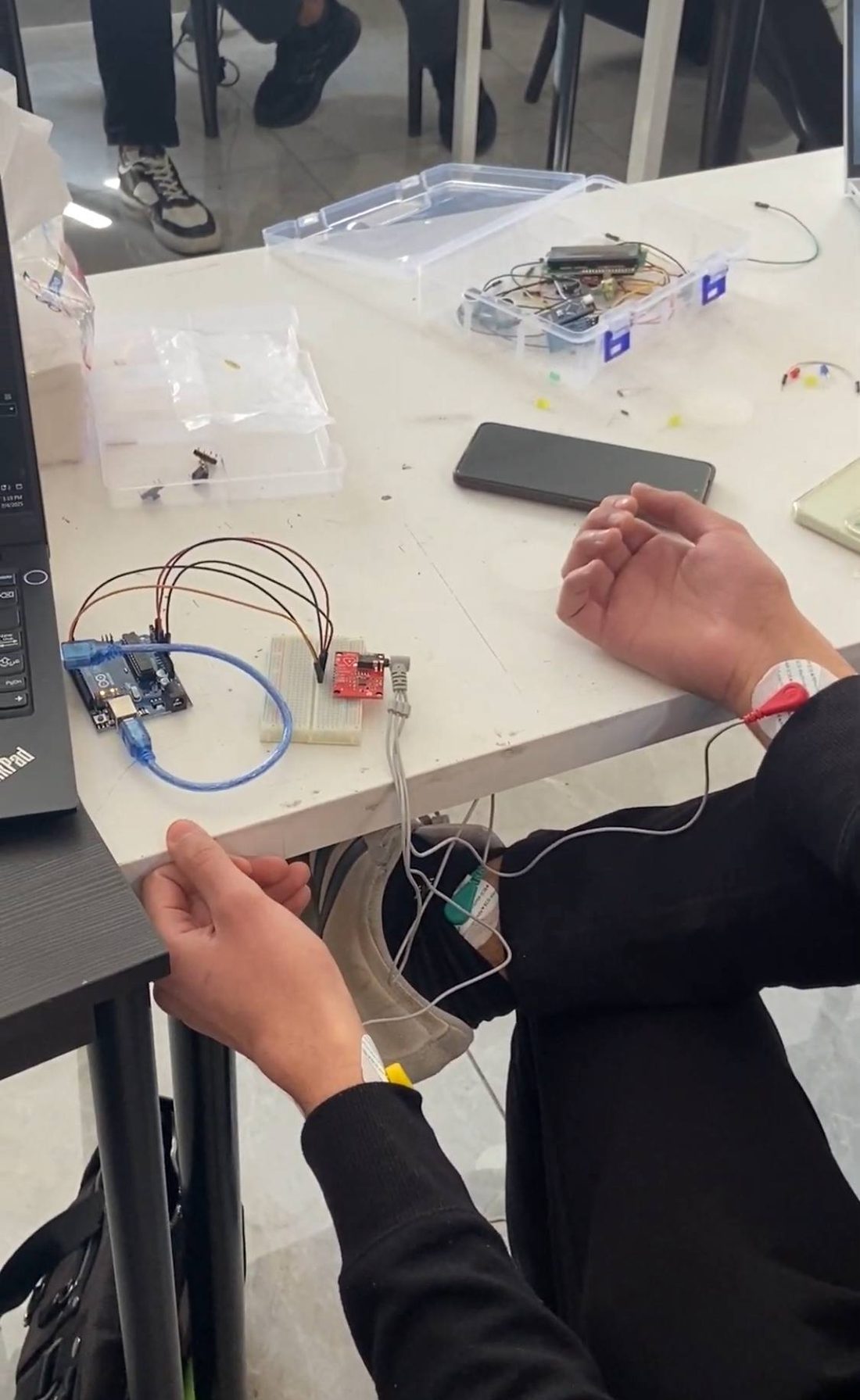 A student wiring an Arduino and biomedical sensor pads during an MCC course