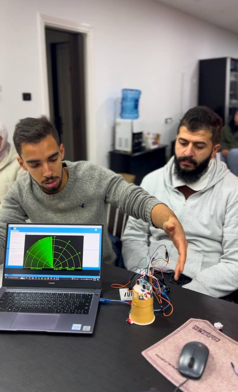 Students testing an ultrasonic radar sensor demo on a laptop during an MCC course