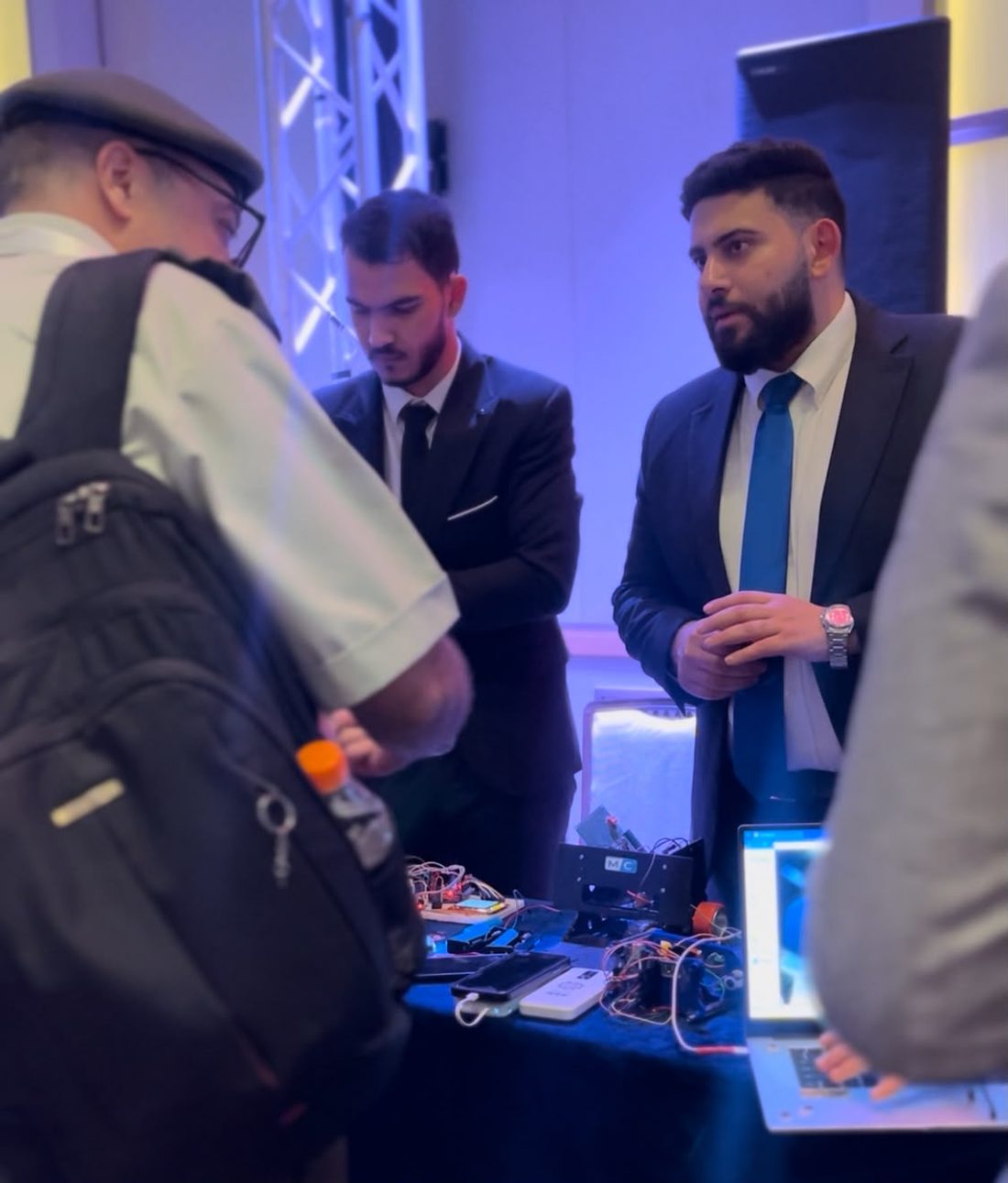 Visitors examining MCC hardware at a conference booth