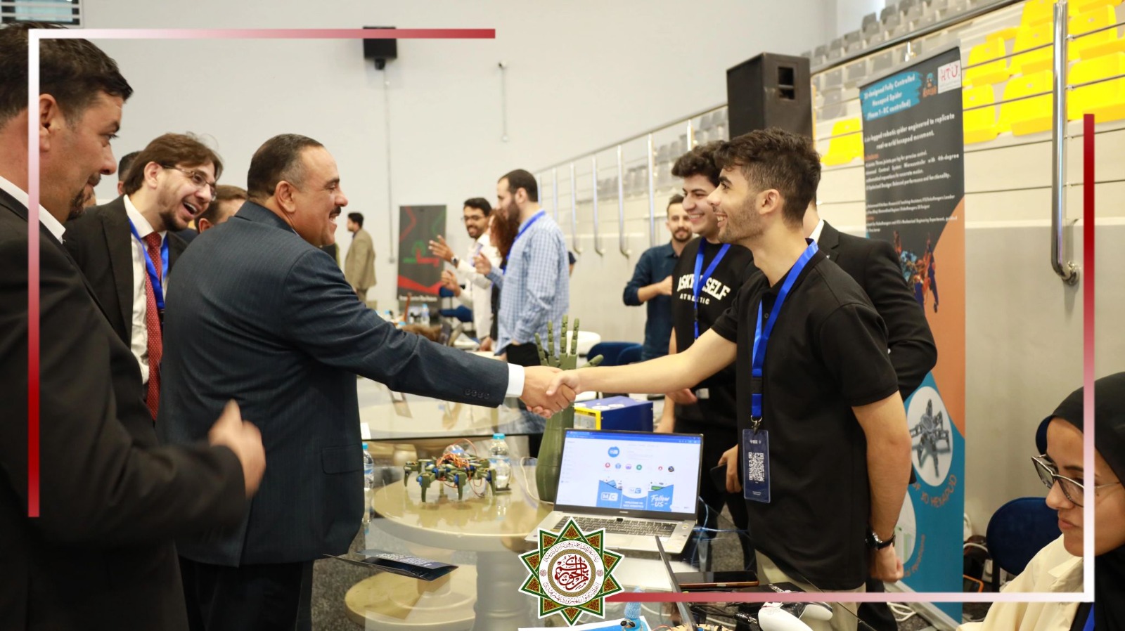 MCC founder greeting a visitor at a technology exhibition booth displaying robotics projects